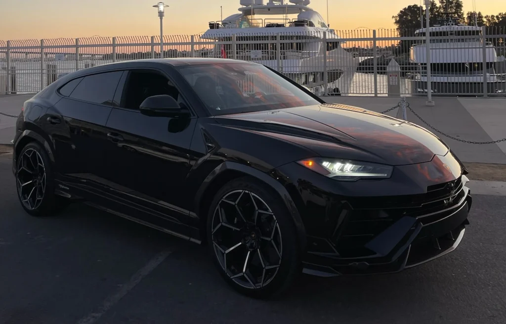 Black Lamborghini Urus Performante luxury SUV rental in San Diego - front three-quarter view at sunset