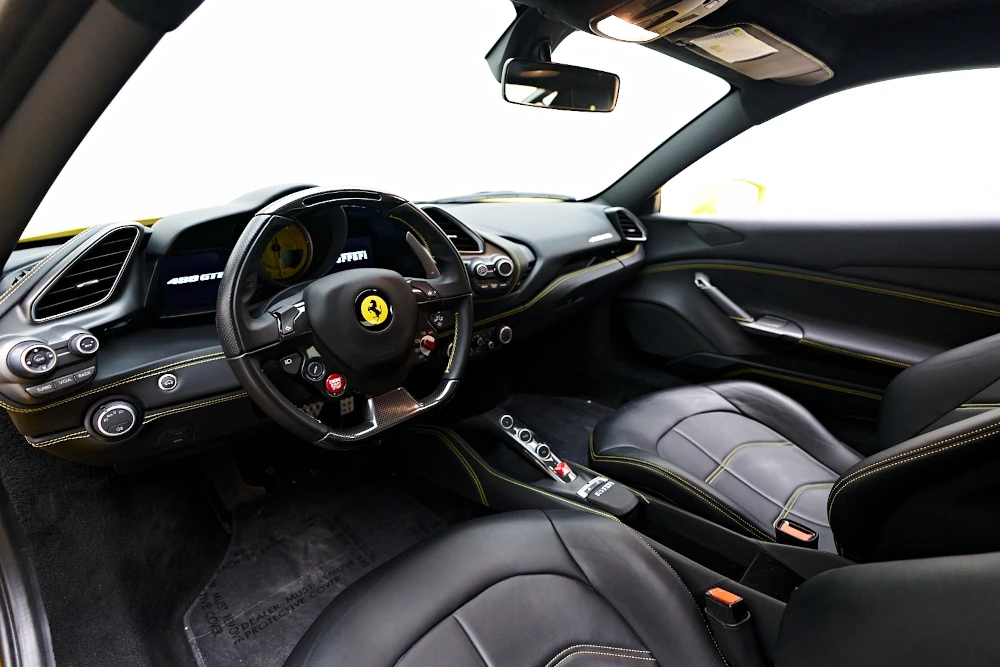 Black Ferrari 488 GTB driver-focused interior with steering wheel and center console